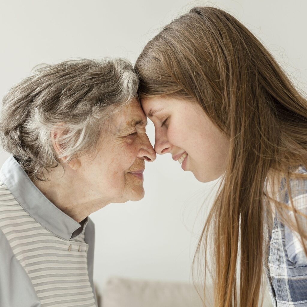 Imagen tierna de una abuela y su nieta frente a frente, simbolizando la unión familiar, alineada con la especialización de Lemnis Abogadas en adopciones de mayores de edad.