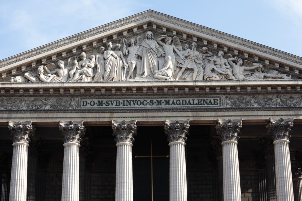 Friso y columnas de la Iglesia de la Madeleine en París, simbolizando la solidez y la autoridad que Lemnis Abogadas ejerce en el ámbito del Derecho Administrativo.