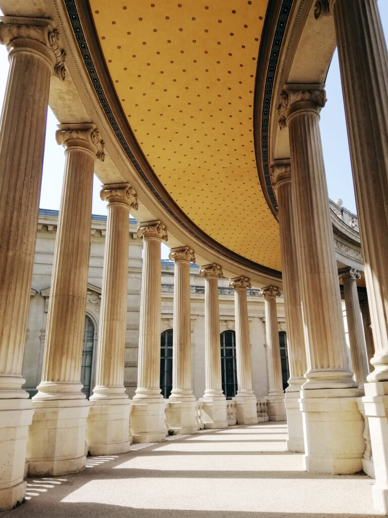 Elegante pasillo de columnas con techo dorado, evocando la majestuosidad y el orden que Lemnis Abogadas aplica en la práctica del Derecho Penal.
